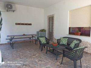 a patio with chairs and tables and a table and a fan at Casa Vacanze Gio&le in Domusnovas