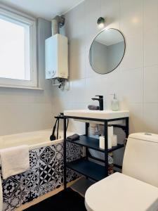 a bathroom with a sink and a toilet and a mirror at Apartament przy Rynku in Olsztynek