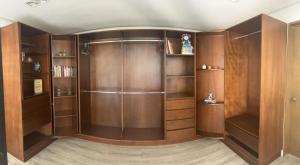 a large closet with wooden cabinets and shelves at Casa helenico in Mexico City