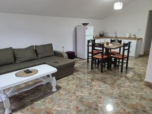 een woonkamer met een bank en een tafel en een keuken bij JS APARTMAN in Nikšić