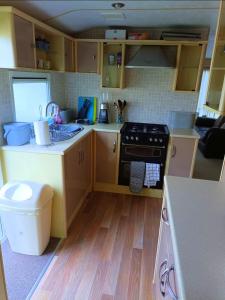 a small kitchen with a sink and a stove at Snowdon Retreat in Llanrug +5 photos
