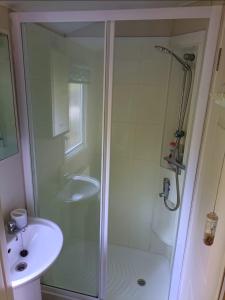 y baño con ducha y lavamanos. en Snowdon Retreat, en Llanrug