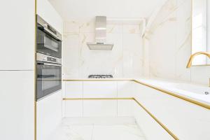 a white kitchen with a stove and a sink at PREMIUM Private Apartment minutes to Central London in London