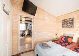 a room with a bed and a flat screen tv at Villa Einola- modern rivercottage with jacuzzi in Pori