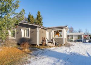 a small house with a porch and a driveway at Villa Einola- modern rivercottage with jacuzzi in Pori