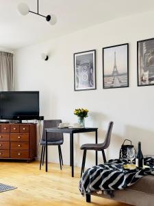Apartament przy Rynku في أولشتينيك: غرفة معيشة مع طاولة ومكتب مع كراسي