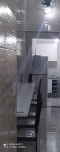 a kitchen with a table and chairs in a room at Pousada Quarto com frigobar,ar e garagem gratuita in Aparecida