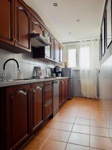 a kitchen with wooden cabinets and a tile floor at Apartament przy Rynku in Olsztynek