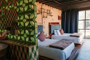 a room with two beds in a room with a wall at Hotel Los Amantes Valle de Guadalupe in Valle de Guadalupe +20 photos