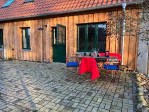 een tafel en stoelen op een patio voor een gebouw bij Broockhof Ferienwohnung unterm Sternenhimmel in Mecklenburg in Reimershagen