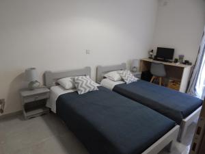 a bedroom with two beds and a desk with a computer at Vera City Apartment in Zakynthos
