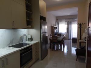 a kitchen with a refrigerator and a table with chairs at Vera City Apartment in Zakynthos