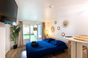 - une chambre avec un lit bleu et une table dans l'établissement Studio charmant & champêtre, à Auch