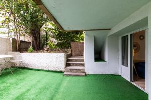 a house with a green carpet on the floor at Studio charmant & champêtre in Auch
