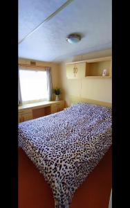 a bedroom with a leopard print bed in a boat at Snowdon Retreat in Llanrug