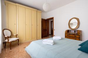 um quarto com uma cama, um espelho e uma cadeira em Casa 94 - Bright apartment, 15min from Venice em Favaro Veneto