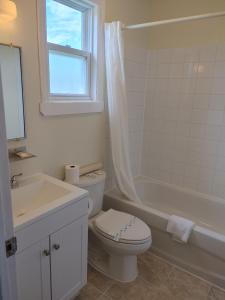 a white bathroom with a toilet and a sink at Tantramar Motel in Sackville