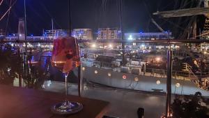 a glass of wine sitting on a table next to a ship at Wellness-Pearl Bremerhaven in Bremerhaven