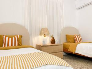 a bedroom with two beds and a table with a lamp at Casa Eve near Gozalandia Waterfalls in San Sebastian