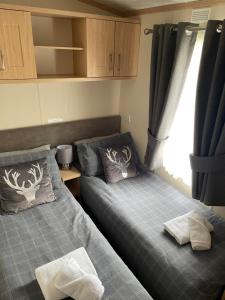 a bedroom with two beds and a window at Freedom Lodge - Aviemore with FREE Starlink Superfast broadband 150mbps - Pet Free in Aviemore