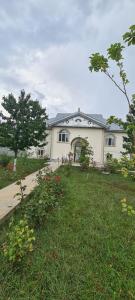 ein weißes Haus mit einem Rasenhof und einem Haus in der Unterkunft Green garden Zargan villa in Qəbələ