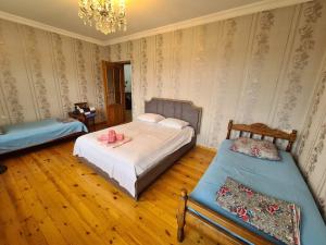 1 Schlafzimmer mit 2 Betten und einem Kronleuchter in der Unterkunft Green garden Zargan villa in Qəbələ