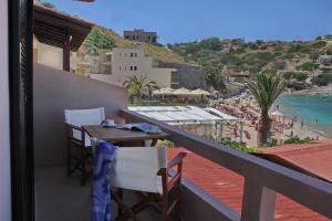 a balcony with a table and chairs and a view of the beach at Lygaria Studios in Agia Pelagia