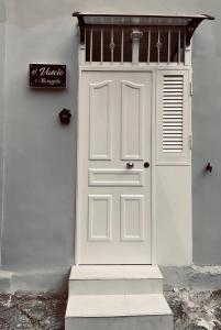 a white door on the side of a building at O’Vascio e maruzzella in Naples