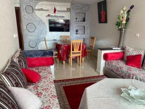 a living room with two couches and a dining room at Appartement avec piscine proche de Sidi Bouzid in El Jadida