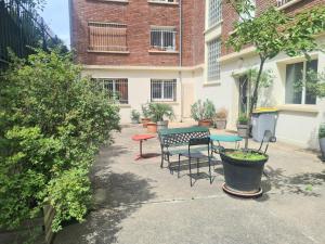 a patio with a table and chairs in front of a building at Appartement F3 55m2 à 5' de Paris in Ivry-sur-Seine