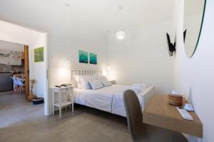 1 dormitorio con cama, mesa y escritorio en Bluebell House Halki, en Halki