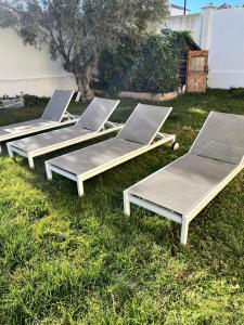 馬尼爾瓦的住宿－Villa Duquesa，草地上摆放着四把躺椅