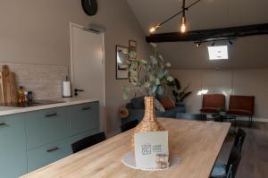 a kitchen table with a vase on top of it at Carré Hotel Zuid-Limburg in Hulsberg