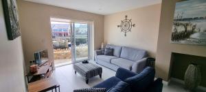 a living room with a blue couch and a tv at The Quays Apartment in Annalong