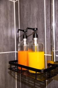 two bottles of orange and yellow liquid on a shelf at La vie en rose - appartement cosy - centre ville in Auch
