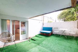 une terrasse avec un canapé bleu, une table et des chaises dans l'établissement La vie en rose - appartement cosy - centre ville, à Auch