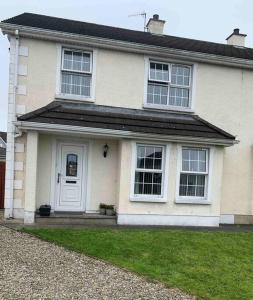 a white house with a white door and windows at Gortamaddy House in Ballycastle