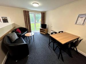 ein Wohnzimmer mit einem Tisch und Stühlen sowie ein Esszimmer in der Unterkunft Spacious Ensuite Room With Shared Kitchen and Living Room in Crewe