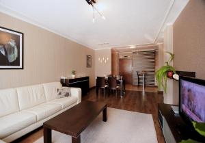 een woonkamer met een witte bank en een tafel bij Apartments Carrera in Sofia