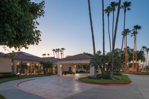 una casa con palmeras y un camino de entrada en Courtyard Anaheim Buena Park en Buena Park