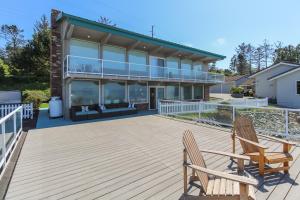 a deck with two chairs and a house at West Beach Retreat in Oak Harbor