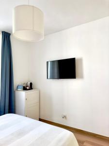 1 dormitorio con 1 cama y TV en la pared en B&B Cellini, en Santa Maria di Castellabate
