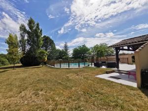 einen Hinterhof mit einem Pool und einem Zaun in der Unterkunft Maison avec piscine 12m * 6m in Civrac-en-Médoc