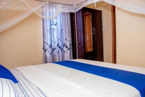 Schlafzimmer mit einem Bett und einem Fenster in der Unterkunft B I G Residence Hotel in Bujumbura
