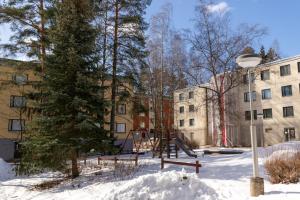 a playground in the snow in front of a building at Cozy budget room w/ balcony in shared apartment in Vantaa