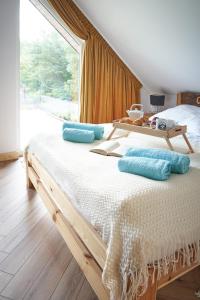 Un dormitorio con una cama con almohadas azules y una ventana en Osada Joniec, en Joniec