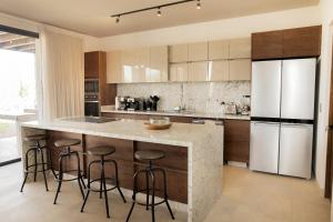 a kitchen with a large island with bar stools at Casa de lujo, hasta con cine privado in San Miguel de Allende