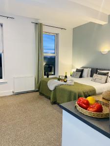 a bedroom with two beds and a table with a bowl of fruit at Martello Hotel in Hull