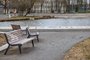 tres bancos de parque sentados frente a un estanque en Centras Prie Parko, Center By The Park, en Klaipėda