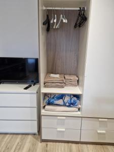 a closet with white drawers and a tv at VYTAUTO 3 apartment in Ukmergė